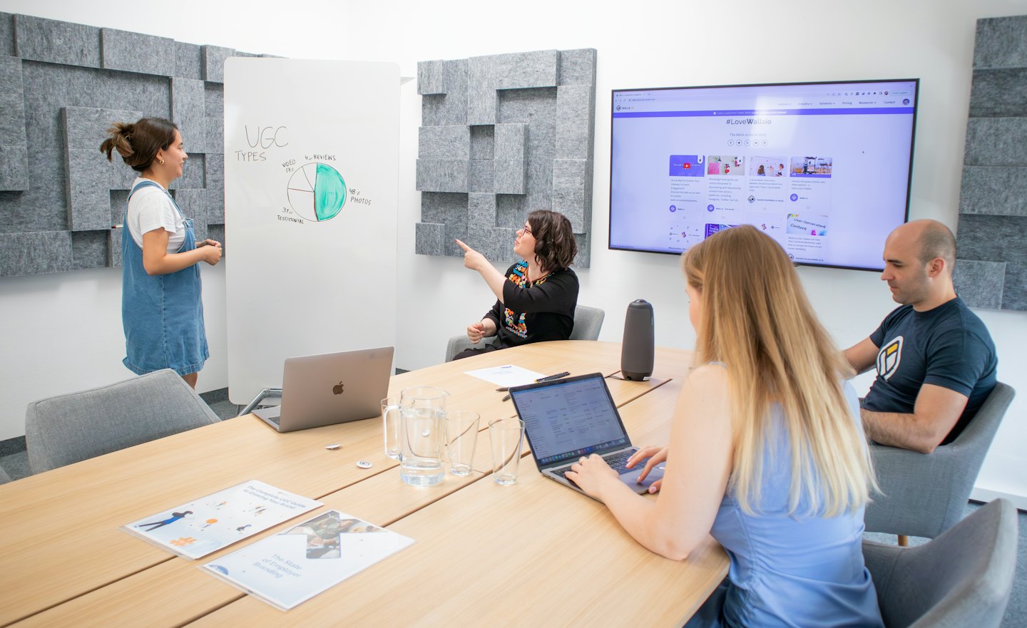 Team collaborates on UGC marketing strategy in a modern meeting room.