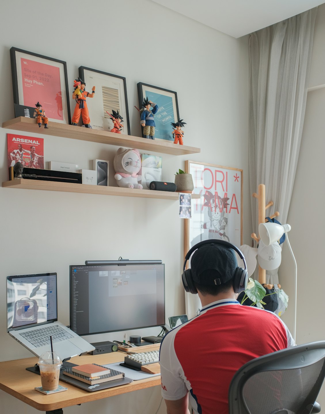 Person wearing headphones works at a desk in a home office.